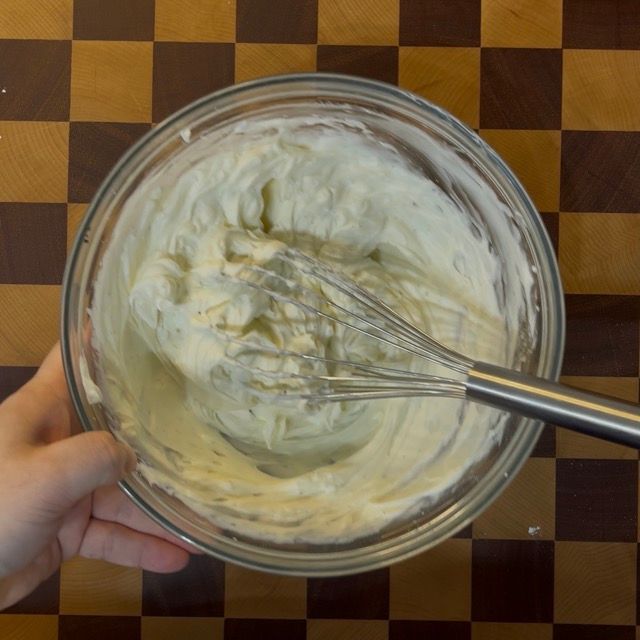 Frusta a mano che mescola il formaggio e lo zucchero.