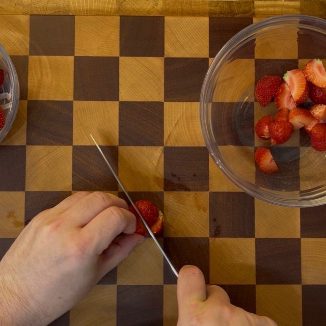 Fragole fresche lavate e tagliate a pezzi in un pentolino.