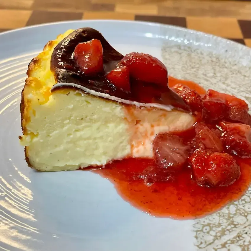 Fetta di Cheesecake Basca che mostra il contrasto tra la crosta bruciata e l'interno cremoso e quasi fondente