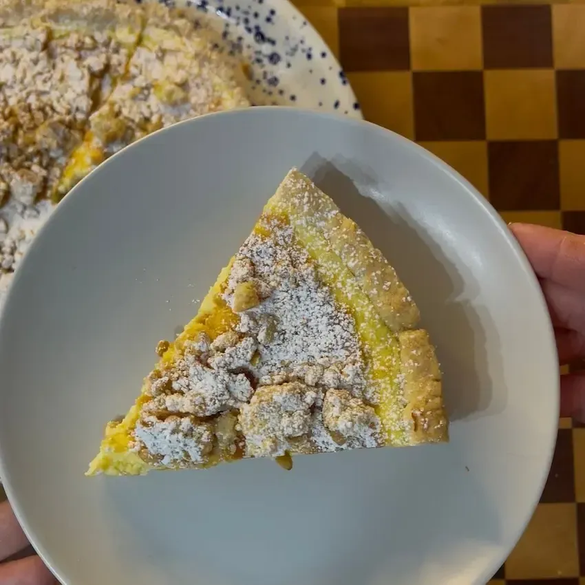 Fetta di cheesecake della nonna al piatto che mostra la consistenza cremosa del ripieno alla crema 