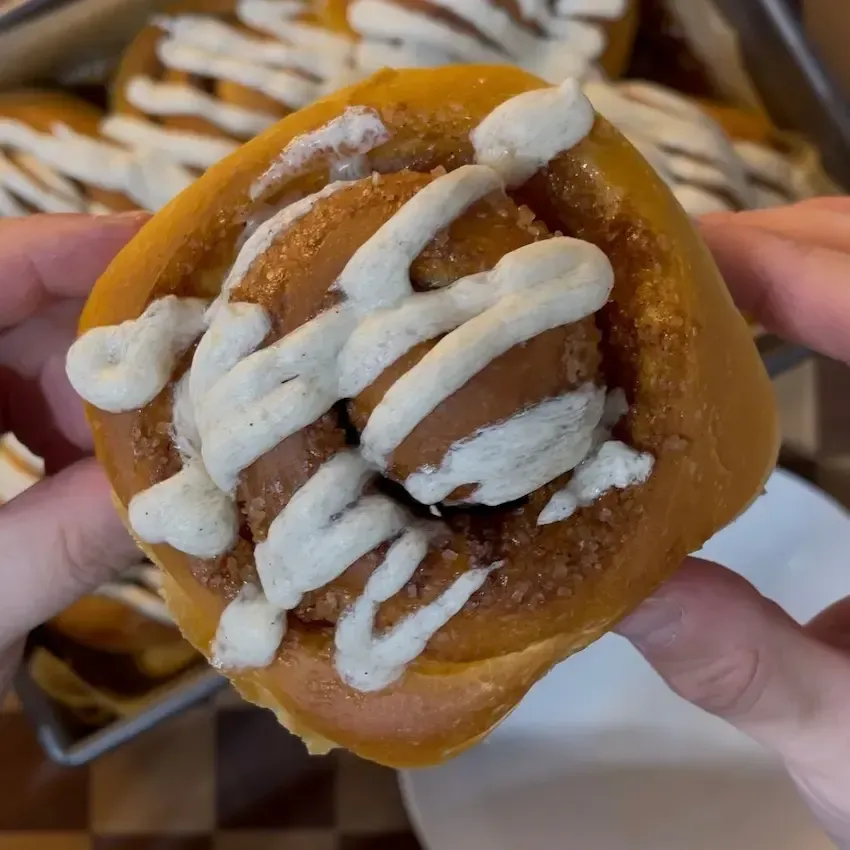 Primo piano di una girella alla cannella che mostra gli strati soffici dell'impasto e il ripieno goloso.