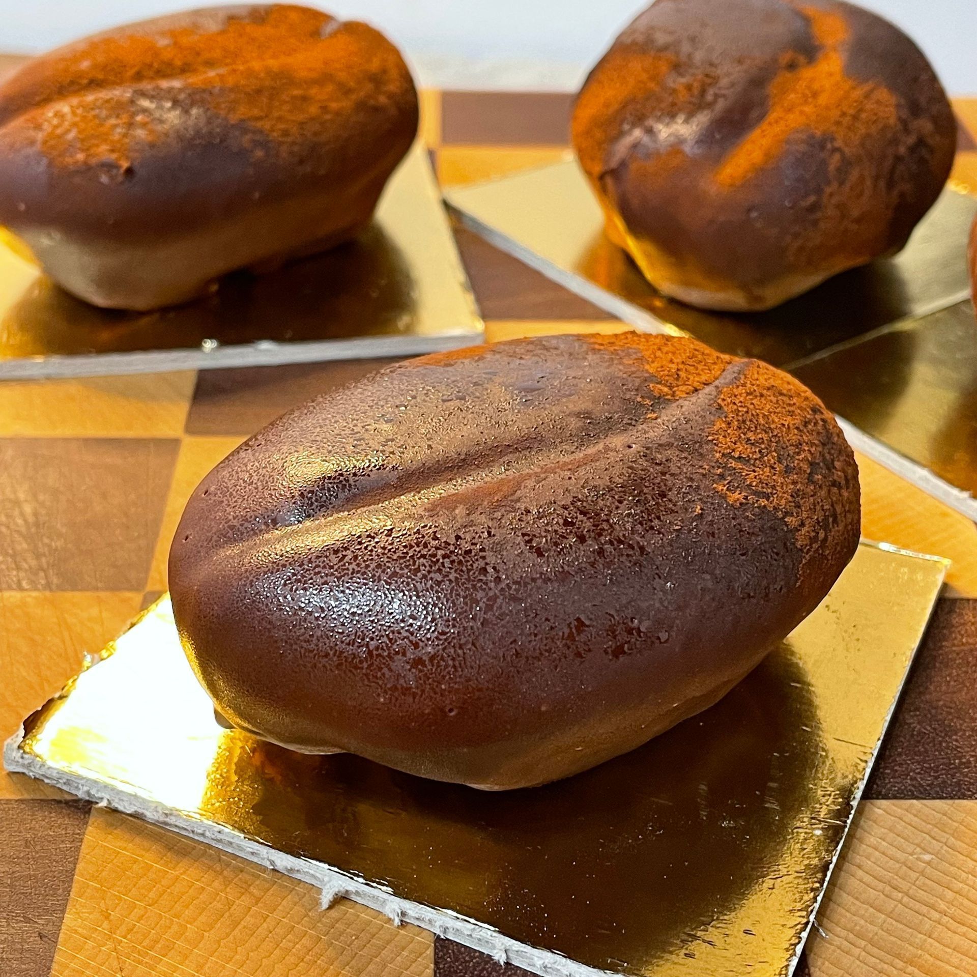 Dolce moderno trompe l'œil a forma di chicco di caffè, con una finitura lucida e realistica