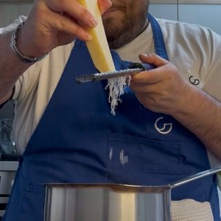 Aggiunta di parmigiano grattugiato poco stagionato alla salsa di pomodoro calda.