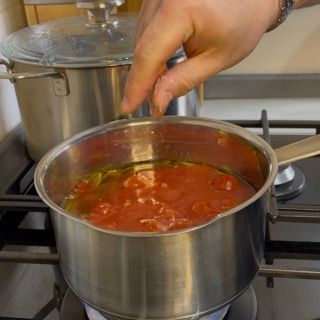 Insaporimento con sale, pepe e acqua per la cottura lenta della salsa.