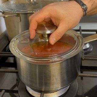 Salsa di pomodoro che cuoce con coperchio per 40 minuti per un sapore intenso.