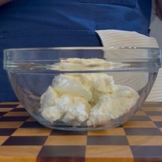 Preparazione della ricotta di pecora in ciotola per i conchiglioni ripieni di ricotta.
