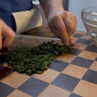 Tritatura degli spinaci lessati pronti da unire alla farcitura.