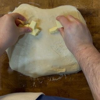 Pezzetti di burro morbido a pomata aggiunti all'impasto allargato.