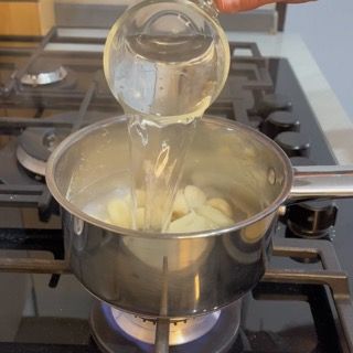Versamento di una nuova dose pulita di acqua e latte per ripetere la bollitura purificante