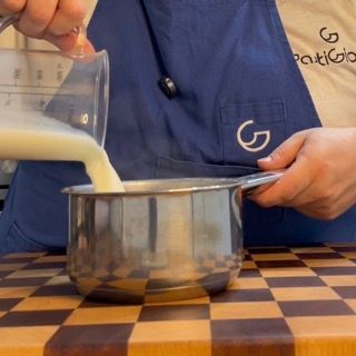 Quinta cottura degli spicchi d'aglio lasciati sobbollire interamente in 240ml di latte puro.