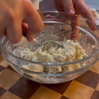 Una persona sta mescolando qualcosa in una ciotola con un cucchiaio