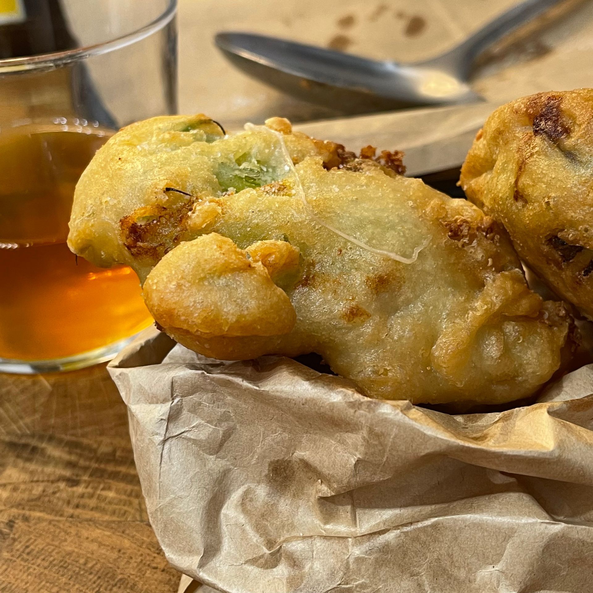 Un primo piano di cibo fritto con un bicchiere di sciroppo sullo sfondo