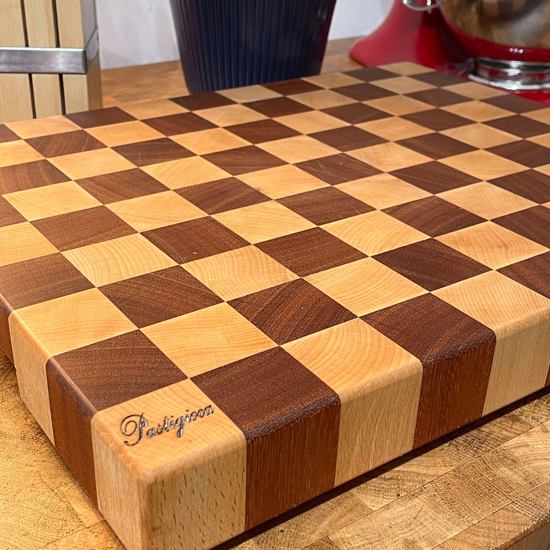 Un tagliere di legno con un motivo a scacchi è appoggiato su un tavolo di legno.