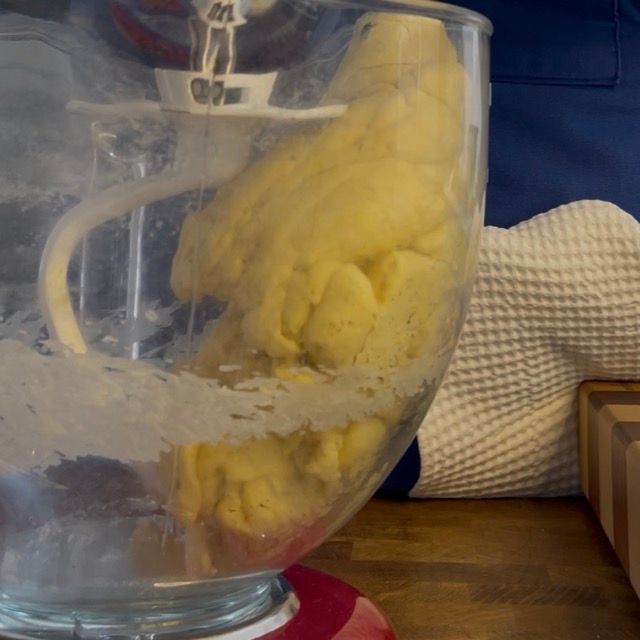 Primo piano dell'impasto con puntini di vaniglia e scorza visibili.