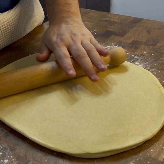 Mattarello che stende l'impasto dei bomboloni a 2 cm di spessore.