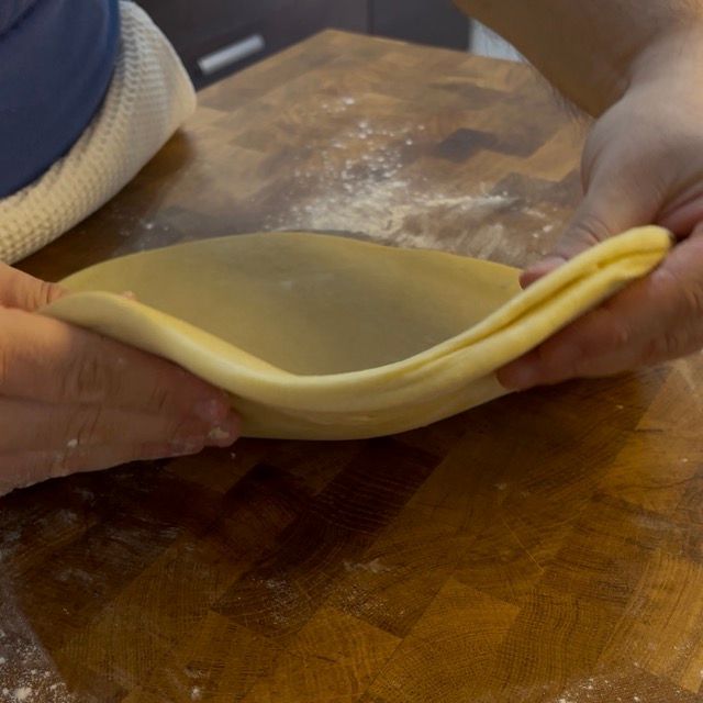 Sfoglia di impasto spessa e uniforme, pronta per il taglio.