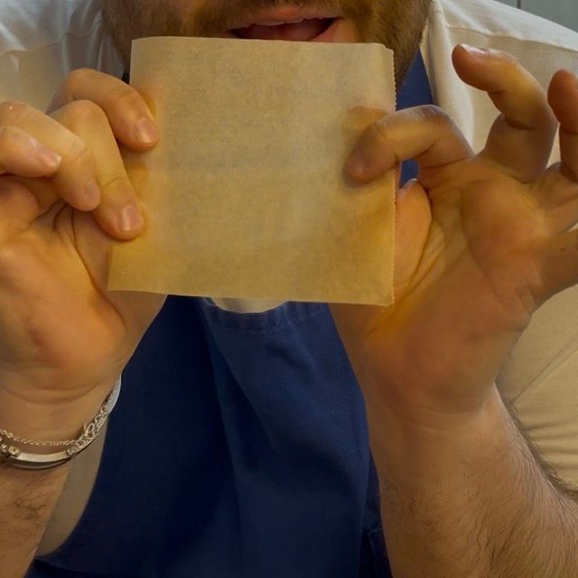 Dischi di pasta per krapfen adagiati su quadrati di carta da forno.