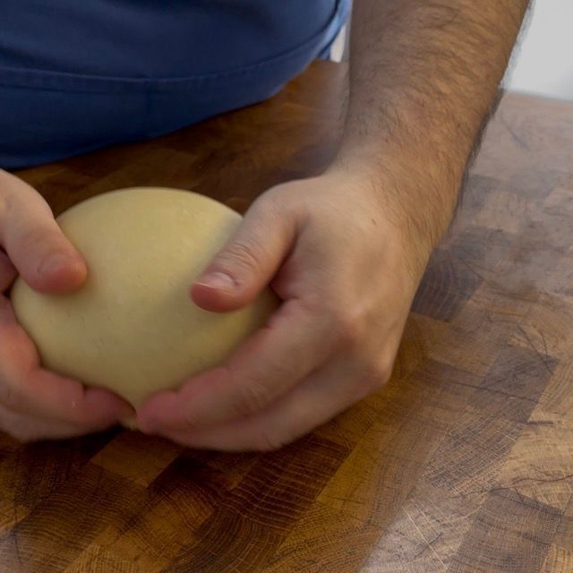 Impasto in un contenitore imburrato, pronto per il riposo.