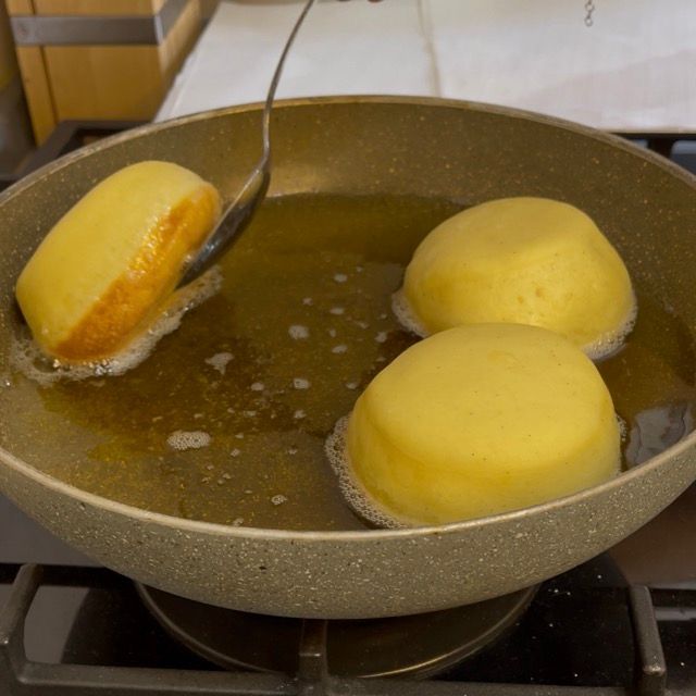 Krapfen dorato da un lato che viene girato.