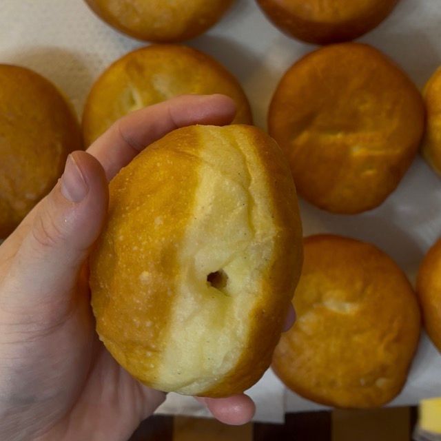 Mano che pratica un foro laterale su un krapfen.