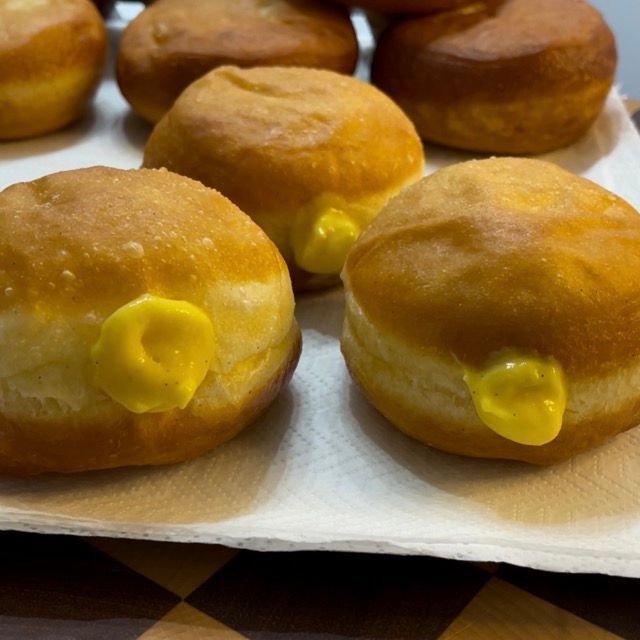 Krapfen e bomboloni farciti disposti su un piatto da portata.