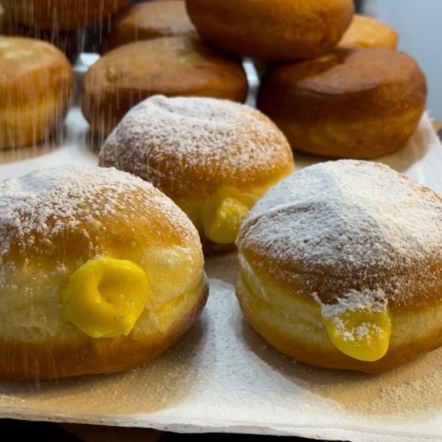 Zucchero a velo spolverato sui krapfen alla crema.
