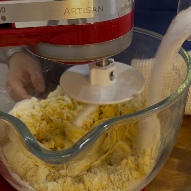Zucchero semolato versato nell'impasto in lavorazione