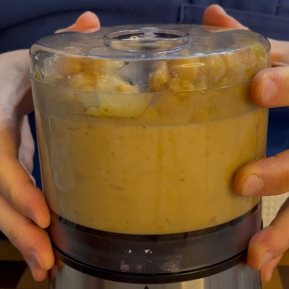 Mixer in azione che frulla i ceci fino a renderli una crema,