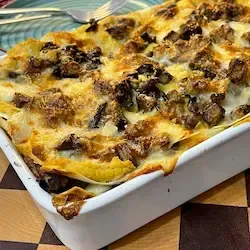 Lasagne vegetariane alle melanzane in una teglia, con uno strato superiore dorato e croccante.