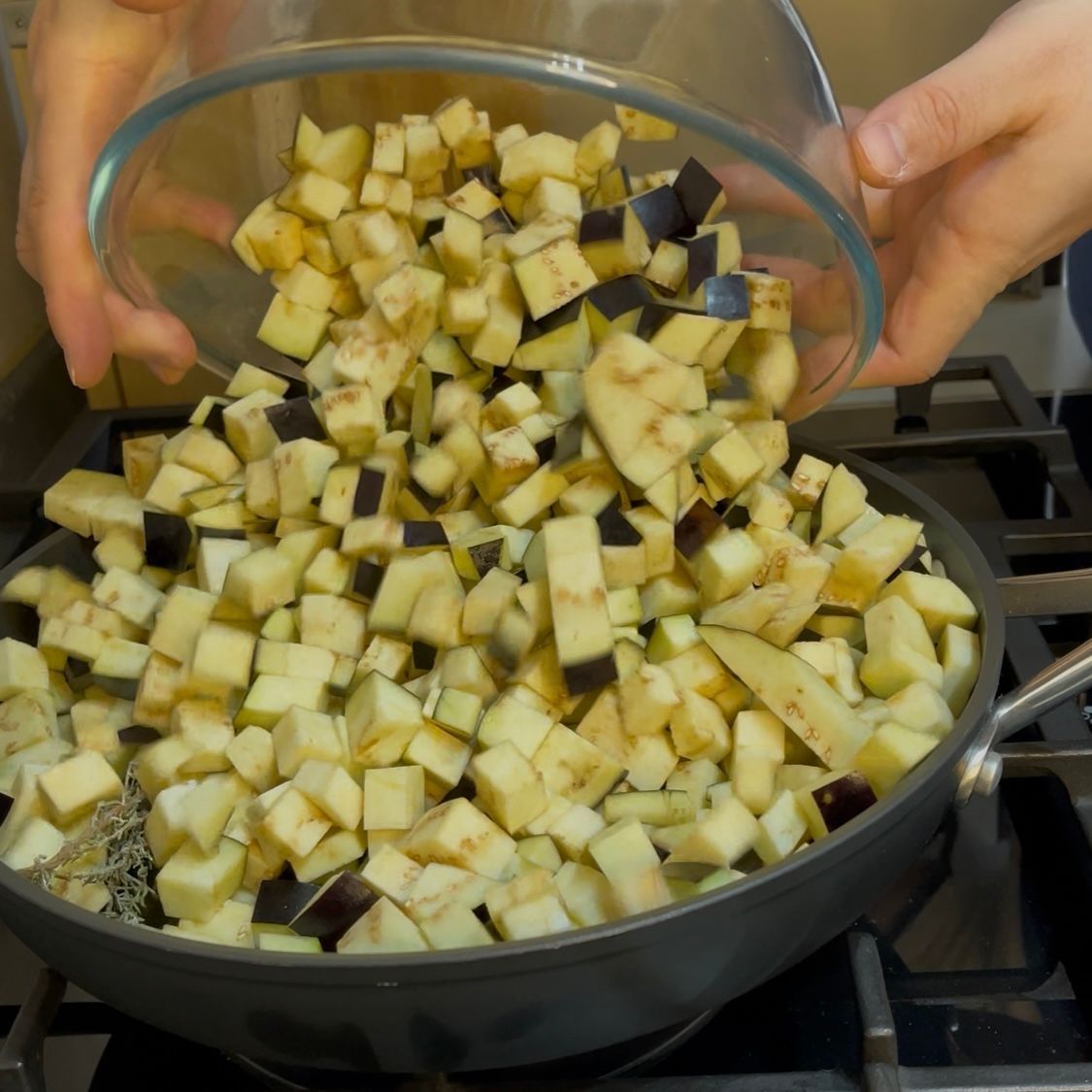 Cubetti di melanzane che cuociono e si dorano in padella