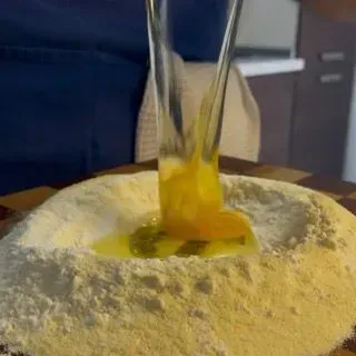 Forchetta che inizia ad amalgamare le uova alla farina