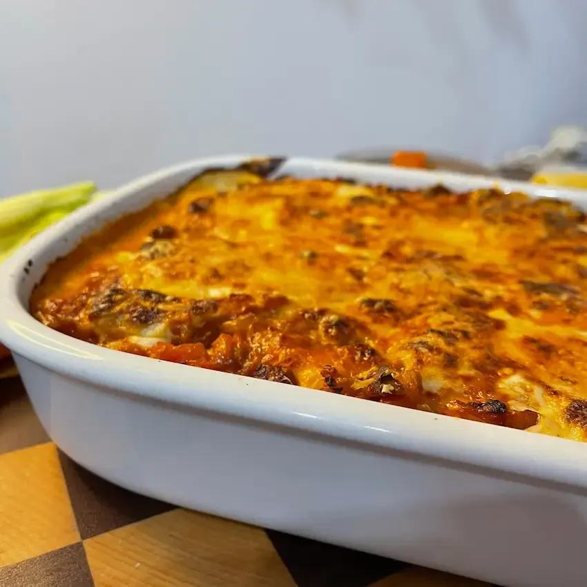 Cannelloni vegetariani al forno farciti con ricotta e conditi con ragù di nocciole e funghi.