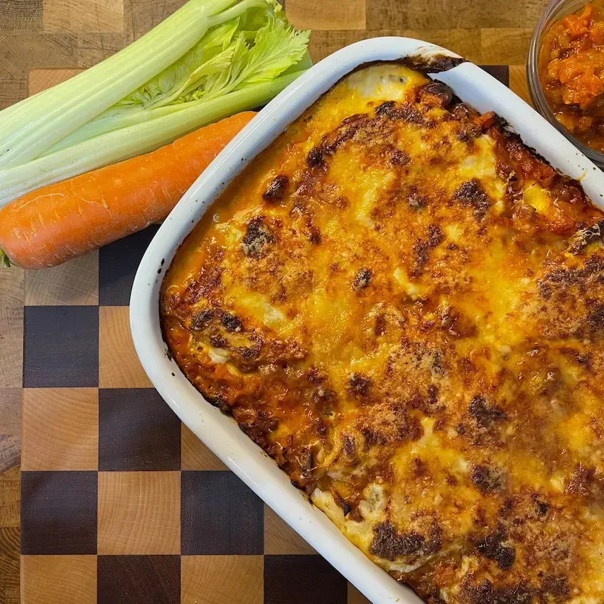 Cannelloni vegetariani al forno farciti con ricotta e conditi con ragù di nocciole e funghi.