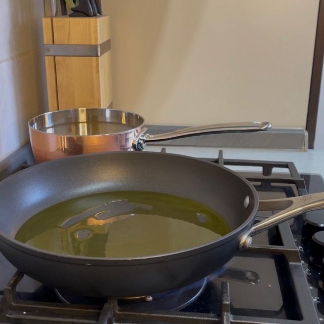 Verdure che appassiscono in olio extravergine d'oliva in un tegame.