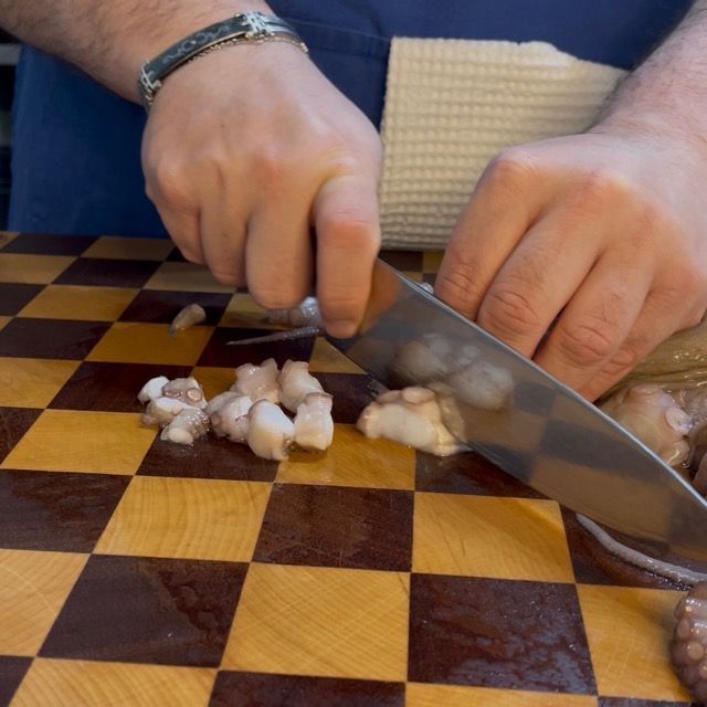 Polpo diviso a metà e preparato per la ricetta del ragù di pesce.