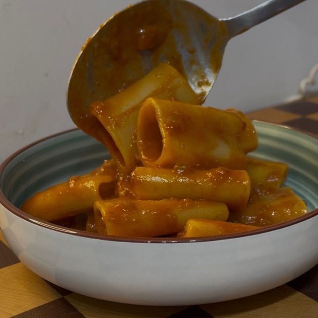 Distribuzione del ragù di polpo sopra i paccheri appena saltati.