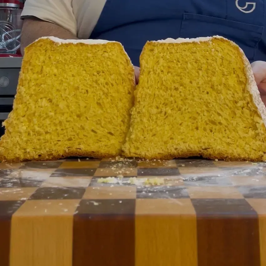 Pandoro fatto in casa con lievito di birra, alto e spolverato di zucchero a velo, forma a stella perfetta.