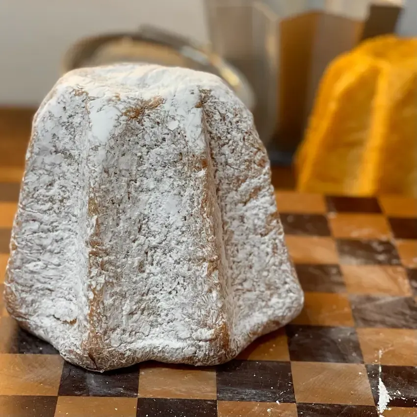 Fetta di Pandoro soffice che mostra l'alveolatura fine e filante ottenuta senza lievito madre.