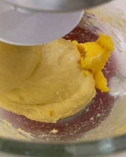 Un mixer sta mescolando un liquido giallo in una ciotola di vetro.