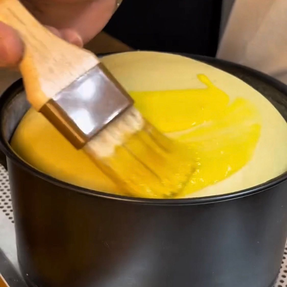 Panettone lievitato fino al bordo, spennellato con miscela di uovo e panna.