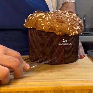 Una persona sta tagliando un panettone su un tagliere