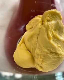 Un primo piano di una sostanza gialla in un becher