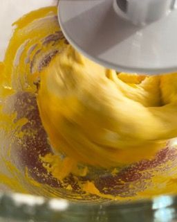 Primo piano di un frullatore pieno di liquido giallo.
