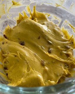 Un primo piano di una salsa gialla in una ciotola di vetro