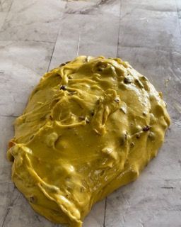 Un grande pezzo di glassa gialla è appoggiato su un tavolo.