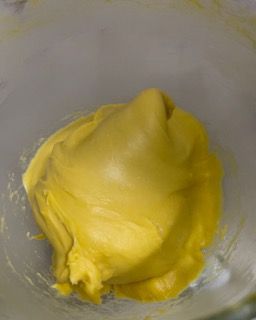 Primo piano di una salsa gialla in una ciotola di vetro.