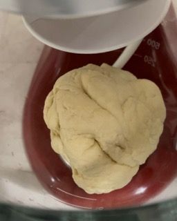 Una palla di pasta viene mescolata in un'impastatrice