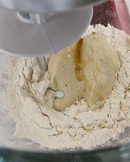 Un'impastatrice sta mescolando un impasto in una ciotola di farina.