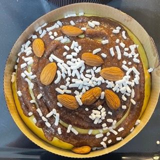 Una torta al cioccolato con mandorle e granella sopra