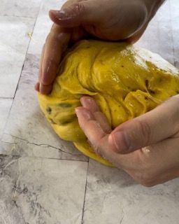 Una persona tiene in mano una palla di pasta gialla